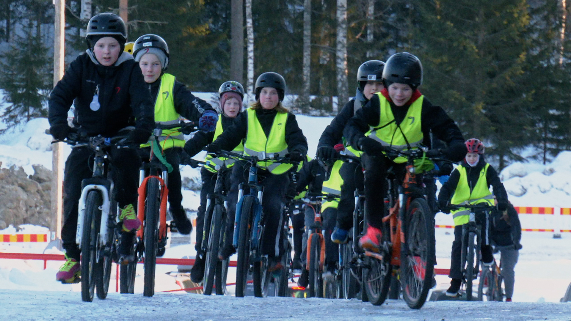 Joukko lapsia pyöräilee.